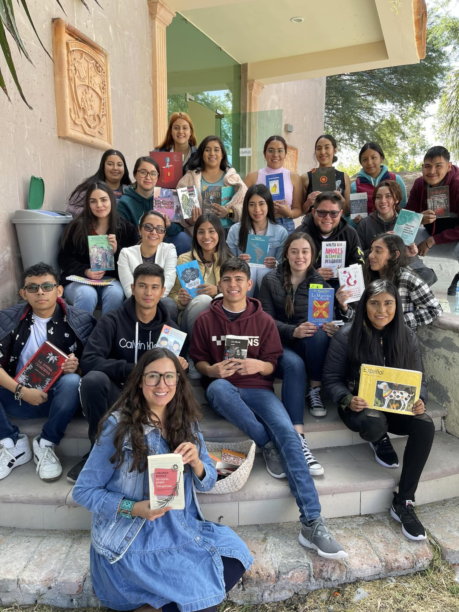 Estudiantes del quinto semestre de la Lic. en Educación Primaria de la Escuela Normal Experimental «Salvador Varela Reséndiz» sentadas y sentados en las escalinatas de la biblioteca José Vasconcelos, en compañía de Itzamá Enríquez Íñiguez, fundadora de Ser Escritura, al término de la charla "Leer y escribir para formar".