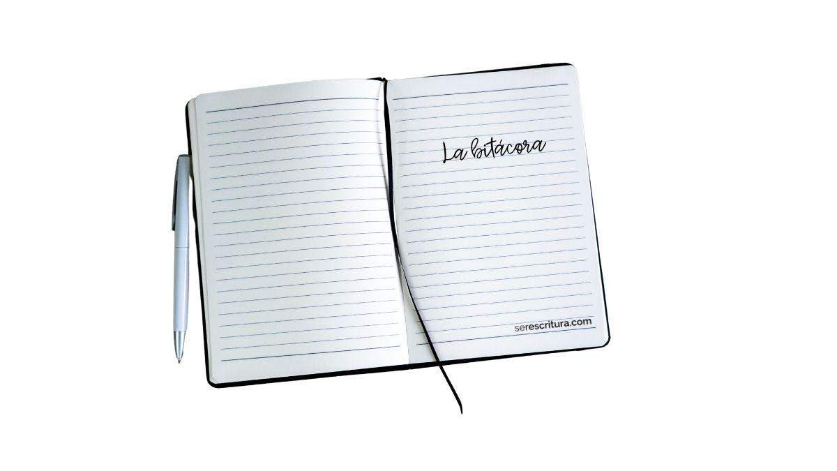 Cuaderno abierto con líneas azules, acompañado de una pluma plateada. En la página derecha se lee “La bitácora” en letra manuscrita, y en la parte inferior está la dirección serescritura.com.